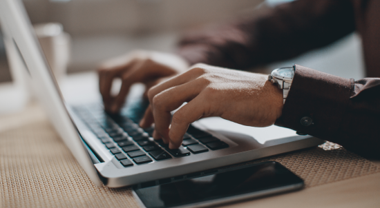 Typing hands on laptop keyboard